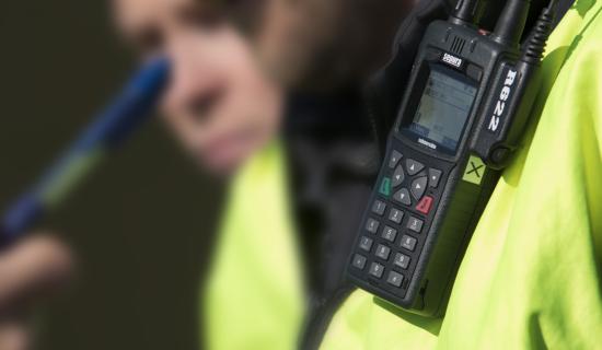 Virvepuhelin palotarkastajan heijastinliivissä